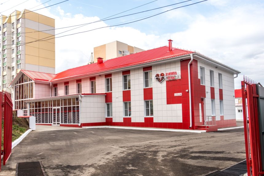 Fachada de uma unidade de saúde moderna, com estrutura em vermelho e branco.