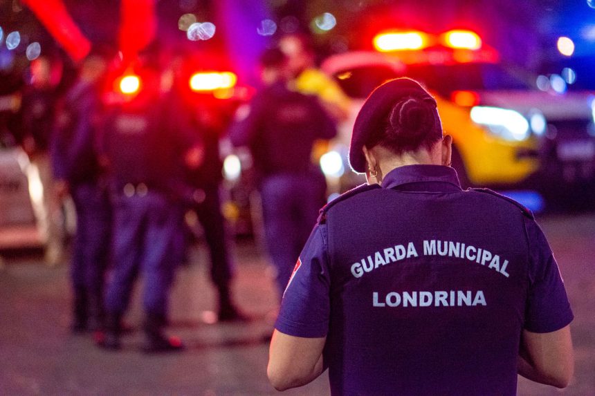 Agente da Guarda Civil Municipal permanece em serviço durante a noite em uma via urbana.